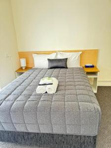 沃东加双城汽车旅馆的一间卧室配有一张床,上面有两条毛巾