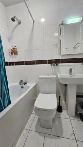 伦敦Bros Inn Hotel的白色的浴室设有卫生间和水槽。