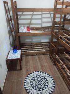 巴拉奈里奥-坎布里乌B & B Hostels Balneário的客房设有双层床、椅子和地毯。
