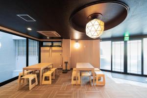 东京TOKYO E JOY INN （East Nipoori Branch）的一间设有桌子、长凳和窗户的房间