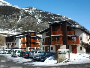 兰斯勒维拉德Appartement Lanslevillard, 2 pièces, 4 personnes - FR-1-508-209的停车场,停车场停在大楼前