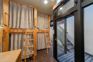 东京TOKYO E JOY INN （East Nipoori Branch）的带两张双层床和滑动玻璃门的客房