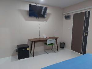 素叻ริมธารริเวอร์เพลส的一间房间,配有一张桌子和一台墙上的电视