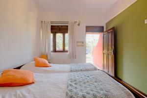科尔瓦Skylark Resort的一间卧室配有两张带橙色枕头的床