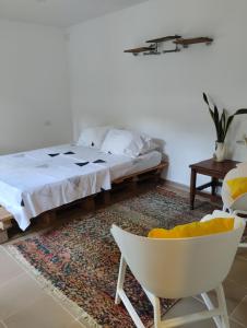 帕洛米诺Hermoso Palomino的一间卧室配有一张床和一张白色椅子