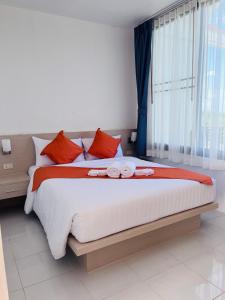 功孟海滩White Seaview Residence的一间卧室配有一张带红色枕头的大床