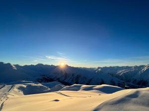 伊施格尔Pension Lenz的雪覆盖的山脉上方的日落