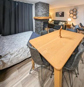 潘诺拉马2 Bedroom and Wall Bed Mountain Getaway Ski In Ski Out Condo with Hot Pools Sleeps 8的一间卧室配有一张床和一张桌子及椅子