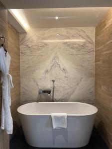 加德满都Hotel Barahi Kathmandu的带浴缸的浴室和大理石墙