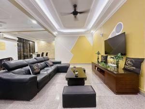 马西C03 Golden Rinting Homestay的客厅配有黑色真皮沙发和平面电视。