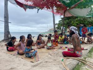 DaanbantayanTribal Huts Community的一群儿童坐在海滩上