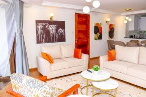 内罗毕Sangara by Edmor Suites的客厅配有白色家具和橙色枕头。