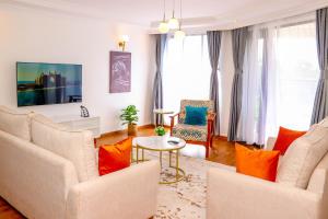 内罗毕Sangara by Edmor Suites的客厅配有白色家具和橙色枕头。