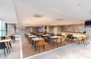 龙岗Vienna International Hotel Shenzhen Baolong subway Station branch的一间在房间内配有桌椅的餐厅