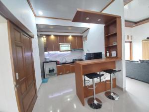 斯勒曼Homestay Jogja Prambanan By Simply Homy的厨房配有柜台和2个酒吧凳