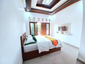 斯勒曼Homestay Jogja Prambanan By Simply Homy的一间带一张床铺的卧室,位于带天花板的房间内