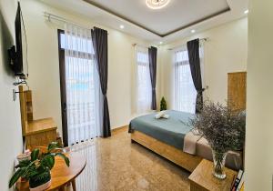 大叻Mai DiaMond Hotel的一间卧室设有一张床和两个大窗户