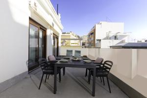 阿利坎特Apartamentos Teatro by Be Alicante的阳台上配有一张黑色的桌子和椅子