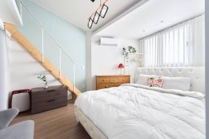 首尔Seochon Secret Cave House的卧室配有白色的床和楼梯。