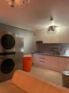 首尔Aufn Orange Bulb的厨房配有不锈钢用具和橙色沙发