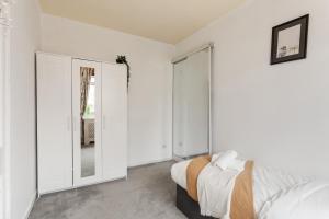 爱丁堡Stunning 2 bed apartment Free Parking的白色卧室配有床和镜子