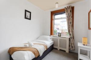 爱丁堡Stunning 2 bed apartment Free Parking的一间小卧室,配有床和窗户