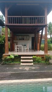 德格拉朗Ubud Sawah Scenery Villa and Homestay的房屋前方设有桌椅