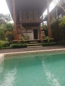 德格拉朗Ubud Sawah Scenery Villa and Homestay的一座房子前面设有游泳池