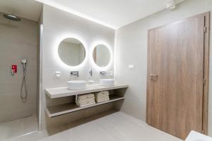 利托斯基简Spa & Wellness Hotel Fitak****的浴室设有2个水槽和2面镜子