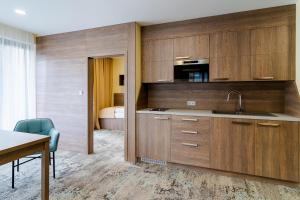 利托斯基简Spa & Wellness Hotel Fitak****的厨房配有木制橱柜、水槽和床。