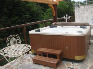 托尔明Pri Mačku的甲板上的热水浴池配有桌子和椅子