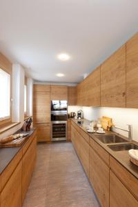 采尔马特Chalet Binna的厨房配有木制橱柜和不锈钢用具