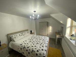 纽里Rostrevor Valley Resort- Full House的卧室配有白色的床和吊灯。