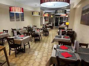 索尔古河畔的恩特莱奎斯Logis Hôtel La Bastide d'Entraigues的用餐室配有桌椅和红色餐巾