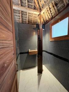 布韦朱TIKI Beach Club & Resort的带淋浴的浴室,设有窗户和门
