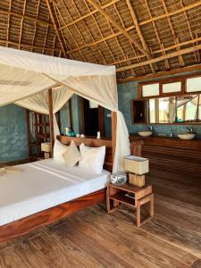 布韦朱TIKI Beach Club & Resort的一间卧室配有一张带天蓬的床