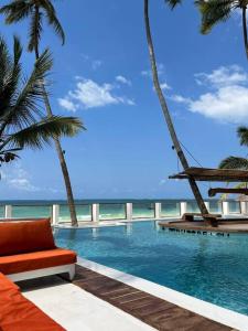 布韦朱TIKI Beach Club & Resort的一个带椅子和棕榈树的游泳池