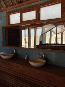 布韦朱TIKI Beach Club & Resort的带2个窗户的浴室内的2个盥洗盆