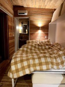 Lissac et MouretLes cabanes de Julie的一间卧室设有一张床和木墙