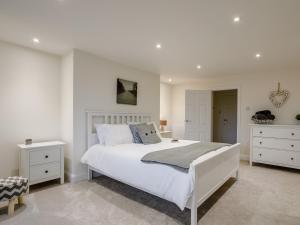 佩恩顿1 bed in Paignton 78200的白色卧室配有一张大床和白色橱柜