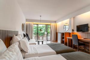 卡马拉海滩Sunprime Kamala Beach的酒店客房设有两张床和电视。