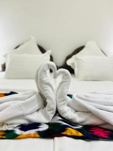 布哈拉Hotel Lola的一张带白色毛巾的床,形成心形