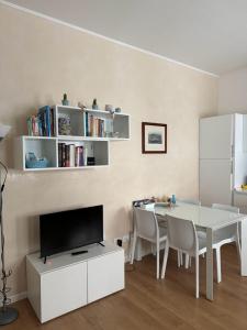 威尼斯Residenza Ca' Matta的一间白色的饭厅,配有桌子和电视
