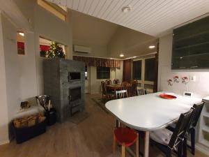 罗瓦涅米Lakeside Salmi的厨房以及带白色桌椅的用餐室。
