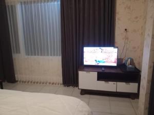 岩望NK Villa Syariah And Cafe Prigen的一间带一张桌子和一张床的电视房间