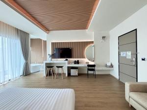 拉差汶里Rock Resort Ratchaburi的一间带一张床的房间和一间带桌子的厨房