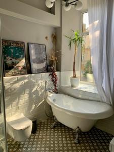 敖德萨豪华公寓酒店的白色的浴室设有浴缸和窗户。