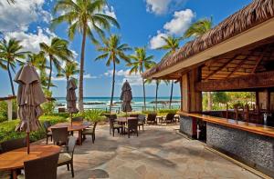 卡波雷Ko Olina Beach Villas O414的一个带桌椅的庭院和海滩