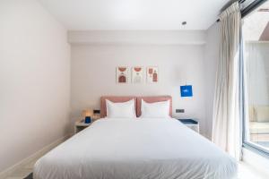 马拉喀什JEMAA EL FNA Suites & Spa的卧室配有白色的床和窗户。
