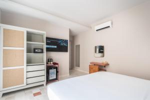 马拉喀什JEMAA EL FNA Suites & Spa的卧室配有白色的床和电视